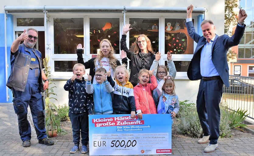 Die Vorsch&uuml;ler des Kindergartens Am Neuen Ufer in M&uuml;hlhausen sind die Th&uuml;ringer Sieger des Wettbewerbs Kleine H&auml;nde, gro&szlig;e Zukunft. Kreishandwerksmeister Roland Reichenbach (links) und der Pr&auml;sident der Handwerkskammer Erfurt, Stefan Lobenstein (rechts), &uuml;bergaben einen Scheck in H&ouml;he von 500 Euro und kleine Geschenke. (Foto: Susann Eberlein/HWK Erfurt)