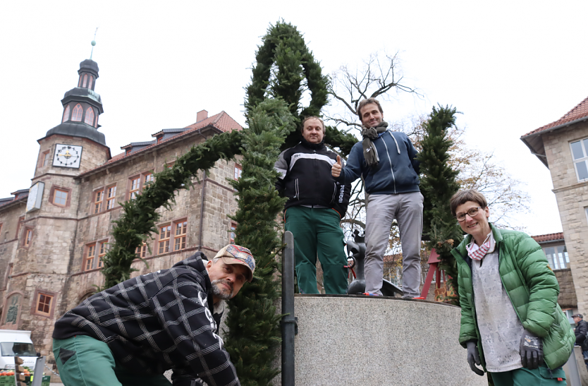 Die Mitarbeiter des VHS Bildungswerks Gerald Becker, Sven Meinicke und Torsten Keitz mit Ausbilderin Petra Bender beim Schm&uuml;cken des Aar-Brunnens vor dem Rathaus (Foto: Stadtverwaltung Nordhausen)