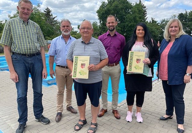 (v. l.): Carl-Josef Detert (Inhaber Detert Zuchttiere), Landrat Harald Zanker, Michael Rönsch (Vereinsvorsitzender Förderverein Freibad Wiegleben), Mittelsömmerns Bürgermeister Thomas Drengenburg, Dorfkümmerin Kathleen Kehr und Jane Croll (Bürgermeisterin Wiegleben) bei der Übergabe. (Foto: Landratsamt)