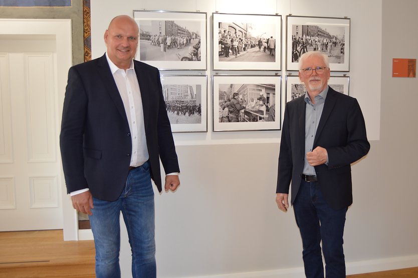  Bürgermeister Steffen Grimm und Henryk Bies vor den Fotos der Ausstellung im Rathaus. (Foto: Janine Skara)