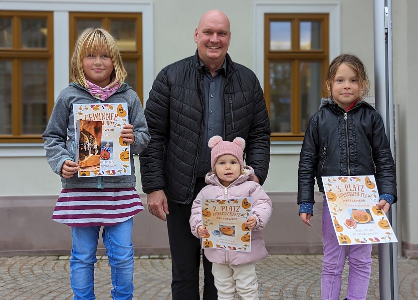 Bürgermeister Steffen Grimm gratulierte den Gewinnerinnen Magda Urban (rechts), Paulina Schubert (vorne Mitte) und Daphne Langhammer (links) des diesjährigen Kürbisschnitzwettbewerbes (Foto: Janine Skara)
