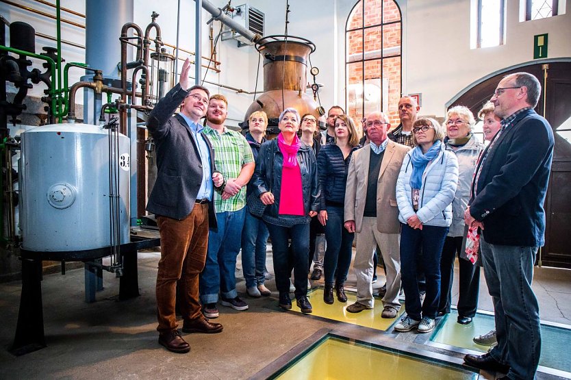 Thomas Müller (links) führt seine Gäste durch den Brennraum (Foto: Traditionsbrennerei)