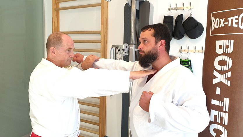 Foto: l. n. r.: Joachim Retzek und Markus Retzek. Fingerstich (Nukite) zum Kehlkopf = eine Atemitechnik (Stoß/Schlag) aus dem Karate und die auch innerhalb der Selbstverteidigung im höheren Kyu-Bereich (höhere Schülergruppe) trainiert wird. (Foto: Joachim Retzek)