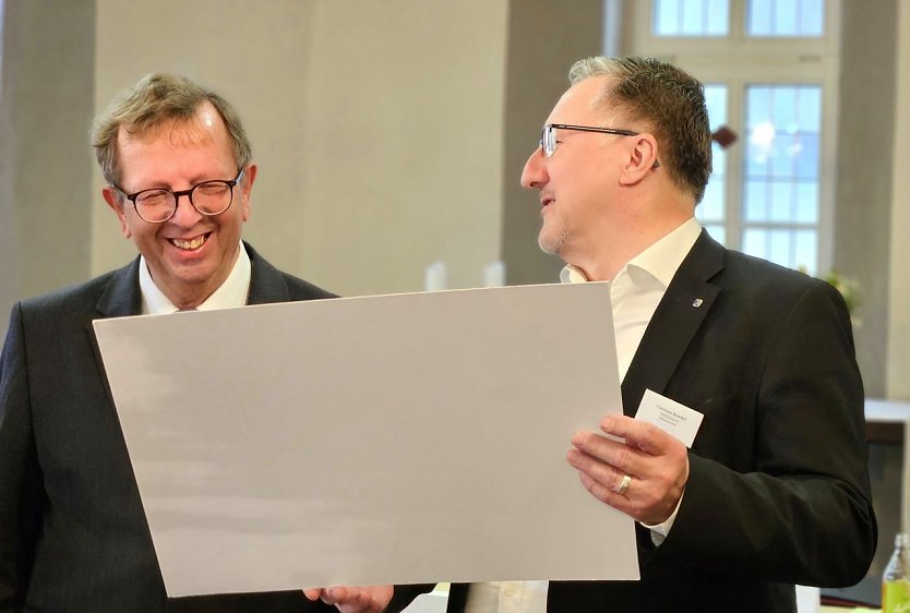 Dr. Werner Henning erhält einen Gutschein aus den Händen von Superintendent Christian Beuchel (Foto: Regina Englert, Evangelischer Kirchenkreis Mühlhausen)