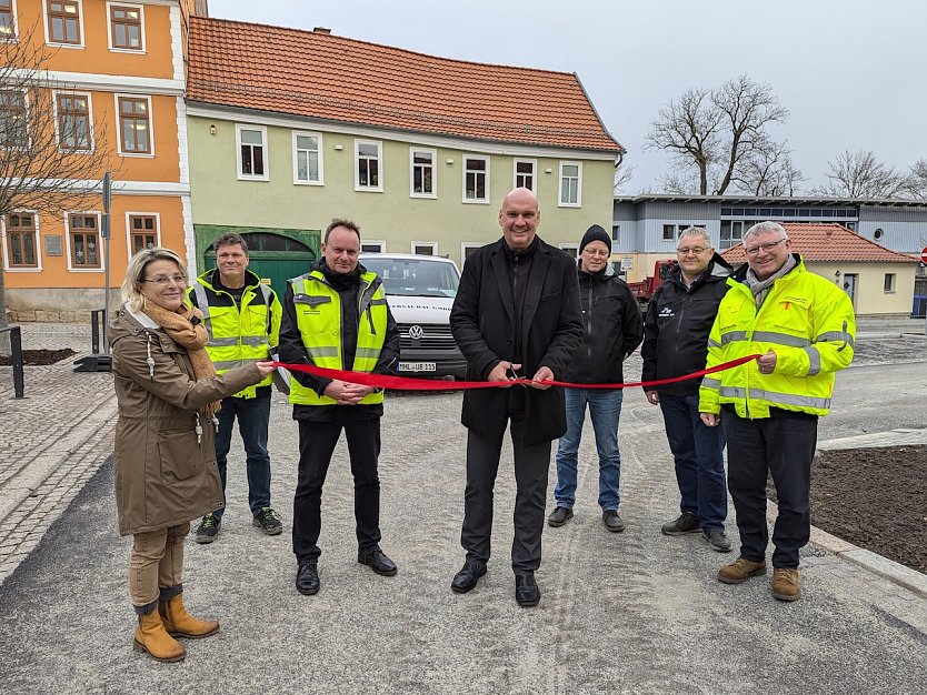 B&uuml;rgermeister Steffen Grimm (Mitte) gab gemeinsam mit Mitarbeitern der Stadtverwaltung und der ausf&uuml;hrenden Baufirma Universal Bau GmbH den Parkplatz am Schwan heute Mittag frei. (Foto: Janine Skara)