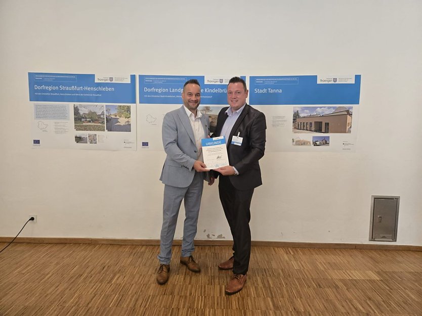 B&uuml;rgermeister Jan Riemann und Christoph Reimann, Fachbereichsleiter f&uuml;r Stadtentwicklung, nahmen die Urkunde f&uuml;r die Dorfregion M&uuml;hlhausen S&uuml;d am 21. August 2025 in Neustadt/Orla entgegen. (Foto: Stadt M&uuml;hlhausen)
