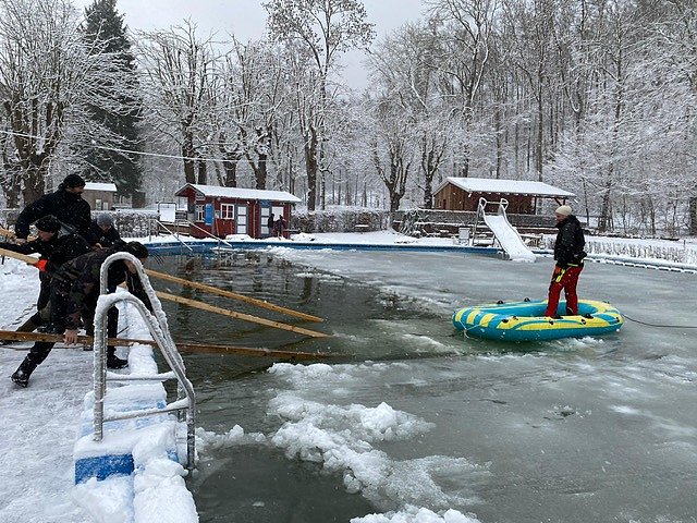 Sascha Buse, Torsten Metelka, Torsten Koch, Alexander Ibe und Roland Gerlach (im Boot) haben am heutigen Freitag gro&szlig;e Eisschollen aus dem Becken des Neust&auml;dter Waldbads herausgeschnitten.  (Foto: Doreen Baufeldt)