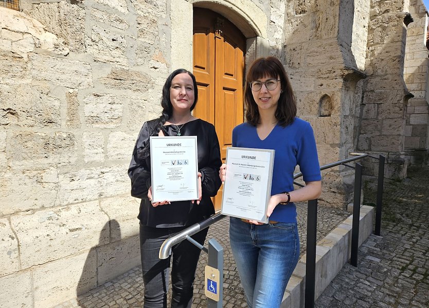 Die Direktorin Dr. Susanne Kimmig-V&ouml;lkner und die stellvertretende Direktorin Sarah P&ouml;nicke mit den neuen Urkunden Reisen f&uuml;r alle (Foto: Matthias Nolte M&uuml;hlh&auml;user Museen)